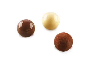 Three chocolate truffles on a white background.