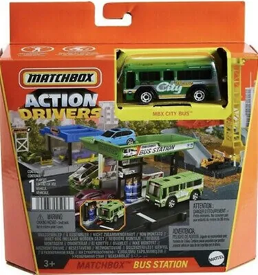 The image shows the packaging of a Matchbox Action Drivers Bus Station playset. The packaging is mostly orange with a clear plastic window displaying the toy.