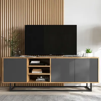 A modern TV stand with a television on top, set against a slatted wooden wall.
