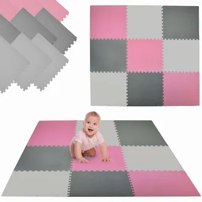A baby crawling on a play mat made of interlocking foam tiles.
