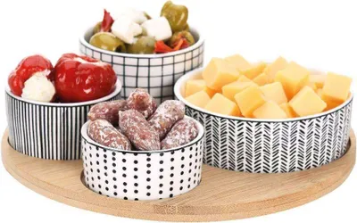Image de Quatre bols en porcelaine sur un plateau en bambou pour servir des friandises