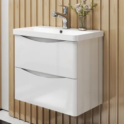 A white bathroom vanity with two drawers and a sink is mounted on a slatted wood-paneled wall.
