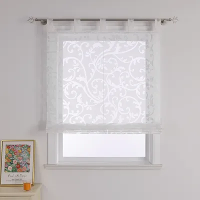 A white sheer Roman blind with a floral pattern is shown hanging in a window.