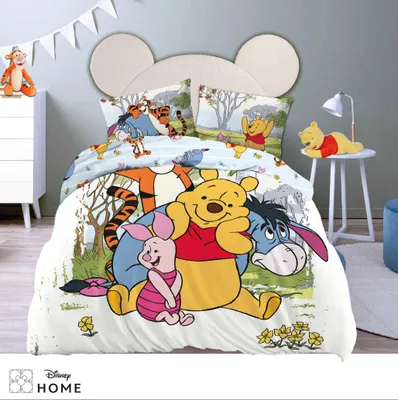 A child's bedroom with a Winnie the Pooh themed bed set.