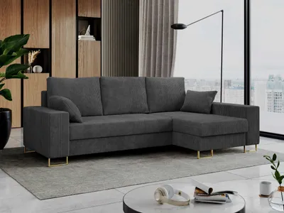 A dark gray sectional sofa with a chaise lounge is placed in a modern living room with wooden accents and large windows overlooking a city skyline.