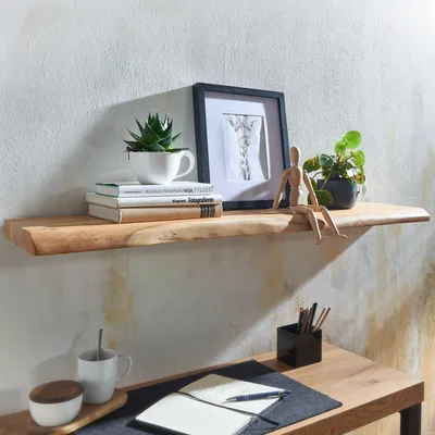 A wooden shelf with decorative items and books, above a wooden desk with office supplies.