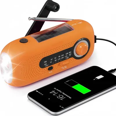 An orange emergency radio is shown charging a smartphone.