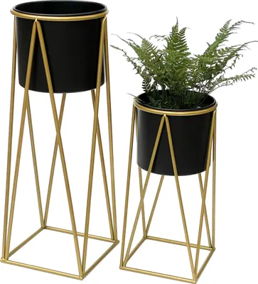 Two black plant pots on gold geometric stands against a white background.