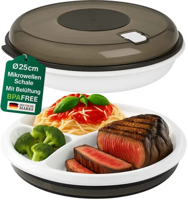 A divided plate filled with food, including steak, broccoli, and spaghetti, with a clear plastic lid. There is a green tag with German text and a German flag logo attached to the lid.