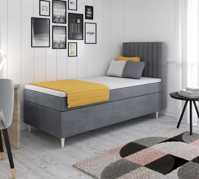 A bedroom scene with a bed, wall art, and a rug.