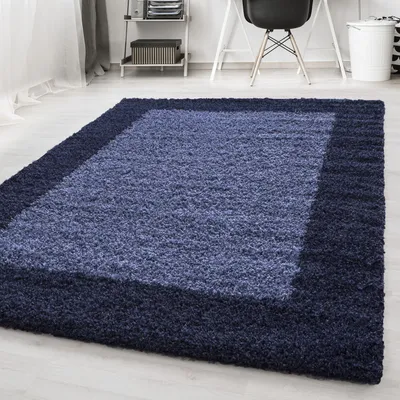 A shaggy rug with a border design in a room with a desk and chair in the background.