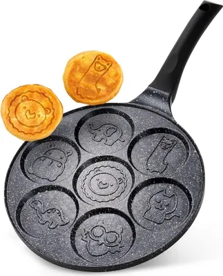 A frying pan with seven animal-shaped molds, with two animal-shaped pancakes on top.