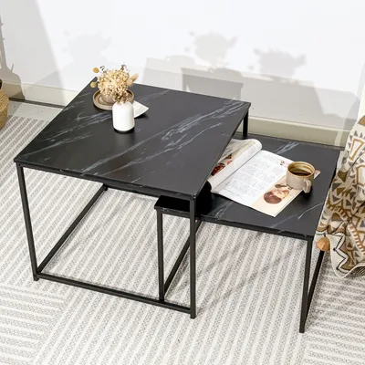 Two nesting coffee tables with a marble pattern are placed on a rug in a room setting.