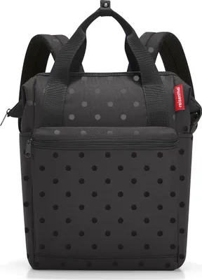 A black backpack with a polka dot pattern.