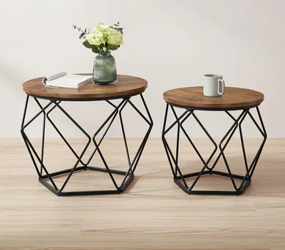 Two round side tables with wooden tops and geometric black metal bases are shown against a plain background.
