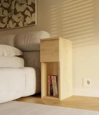 A bedside table with books next to a bed, with blinds casting shadows on the wall.