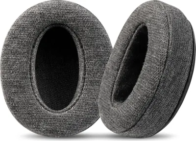 Two dark gray headphone ear pads are shown from a diagonal angle against a white background.