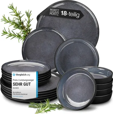 A stack of dark gray and blue ceramic plates and bowls, with a sprig of rosemary in the background. A badge from 'Vergleich.org' is overlaid on the stack of plates.