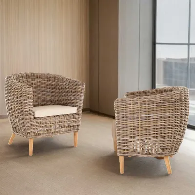 Two rattan club chairs are shown in a room with neutral-toned walls and flooring.
