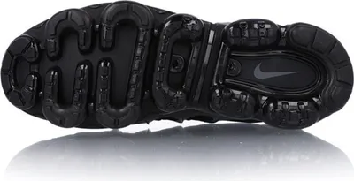 The underside of a black Nike Air VaporMax Plus shoe.
