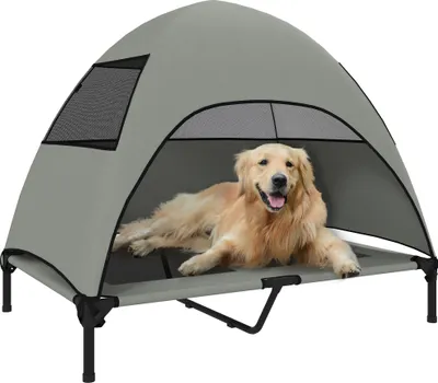 A golden retriever dog is lying on an elevated pet bed with a canopy.