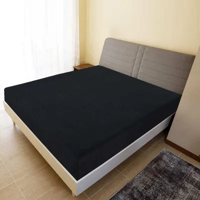 A black fitted sheet is shown on a bed in a bedroom.