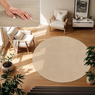 A circular beige rug is placed on a wooden floor in a living room setting, with a chair and plants nearby.