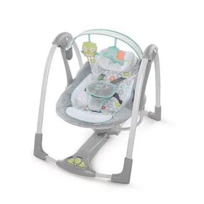 A baby swing with toys hanging from the top.