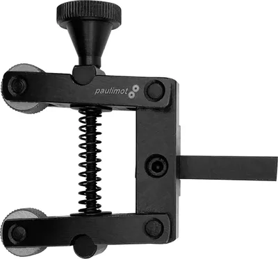 A black metal tool with wheels and a spring, likely a clamp or cutting tool.