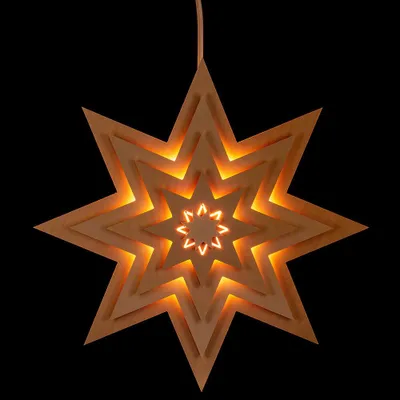 A star-shaped lantern with multiple layers, illuminated from within, against a black background.