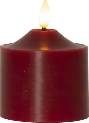 A close-up studio shot of a red LED candle with a flame.