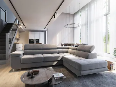 A modern living room with a large sectional sofa, dining area, and staircase.