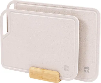 Two beige cutting boards are stacked and held by a wooden stand.