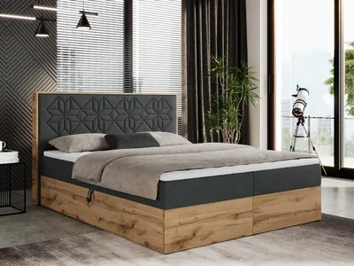 A bedroom scene featuring a boxspring bed with a dark gray upholstered headboard and a wooden base. The bed is made with gray bedding and pillows. The room has large windows with blinds and dark curtains, and a telescope is visible through the window.