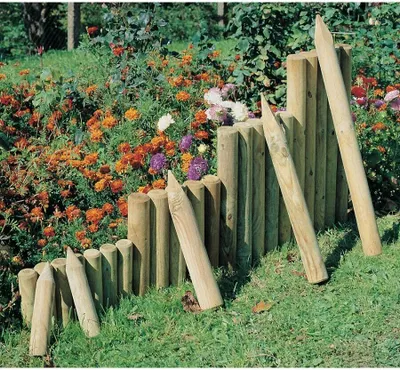 A garden scene with wooden border posts and colorful flowers.