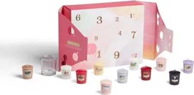 A Yankee Candle advent calendar with votive candles and a candle holder.