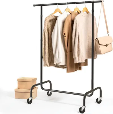 A black garment rack with clothes and a handbag hanging on it, placed on a white background.