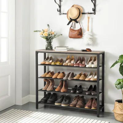 A shoe rack filled with shoes in a hallway. A hat and purse hang on a rack above.