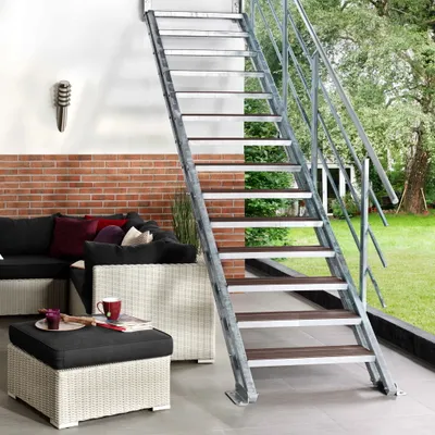 An outdoor patio with furniture and a metal staircase.