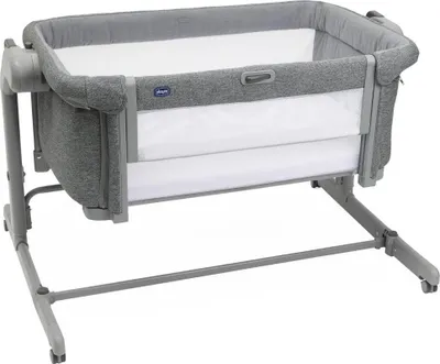 A gray and white co-sleeper bassinet is shown against a white background.
