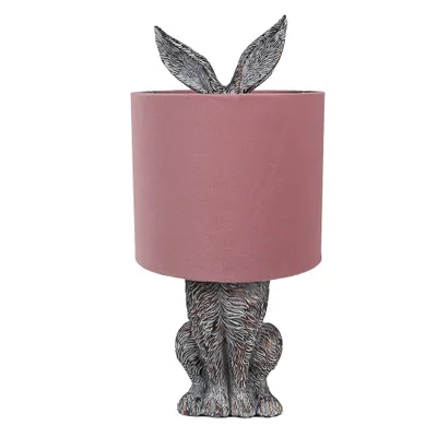 A table lamp shaped like a rabbit with a pink lampshade.