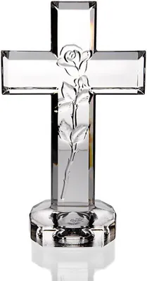 A clear, professional studio shot of a crystal cross with a rose etched into it, set on a faceted base.