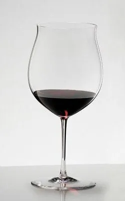A clear studio shot of a wine glass filled with red wine.
