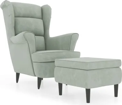 A light gray velvet wingback chair with a matching ottoman.