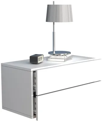 A white bedside table with a lamp and a small digital clock on top.