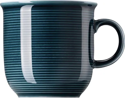 A close-up studio shot of a blue mug with horizontal ridges.