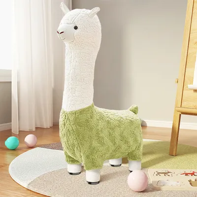 A plush alpaca stool is placed on a rug in a child's room, with toys scattered around.
