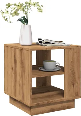 A wooden side table with a vase of flowers and a cup of coffee on it.