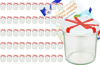 A collection of small glass jars with red ribbon bows on their lids, along with a recipe booklet.
