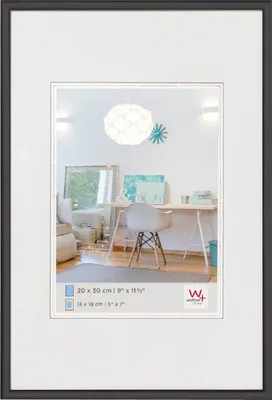A framed picture of a room interior with a desk and chair.